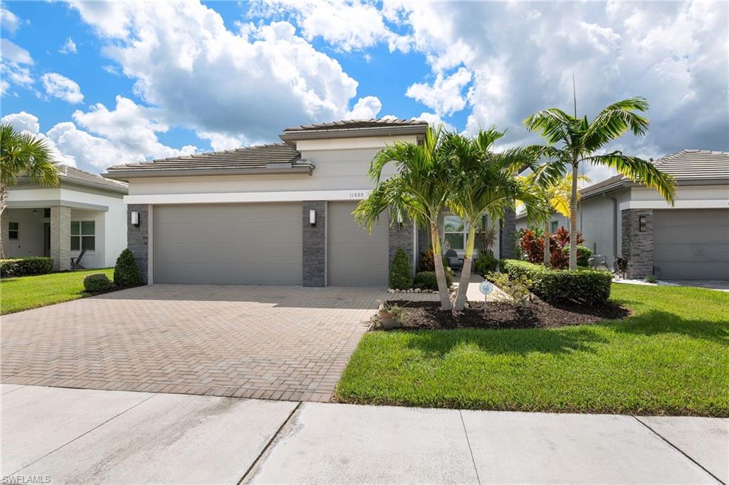 11488 Coronado Way Naples, FL 34120 - Photo 41 of 50 a front view of a house with a yard and a garage