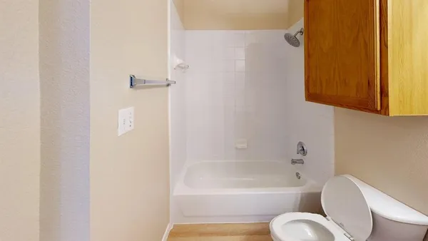 a bathroom with a toilet tub sitting next to a window