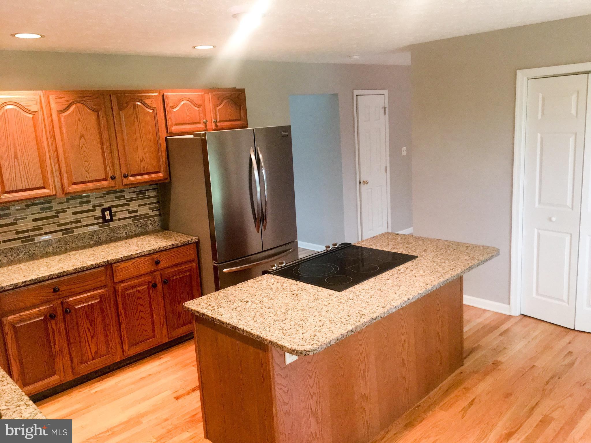 127 Holiday Road Cross Junction, VA 22625 - Photo 12 of 29 a kitchen with stainless steel appliances kitchen island granite countertop a refrigerator a stove and a sink