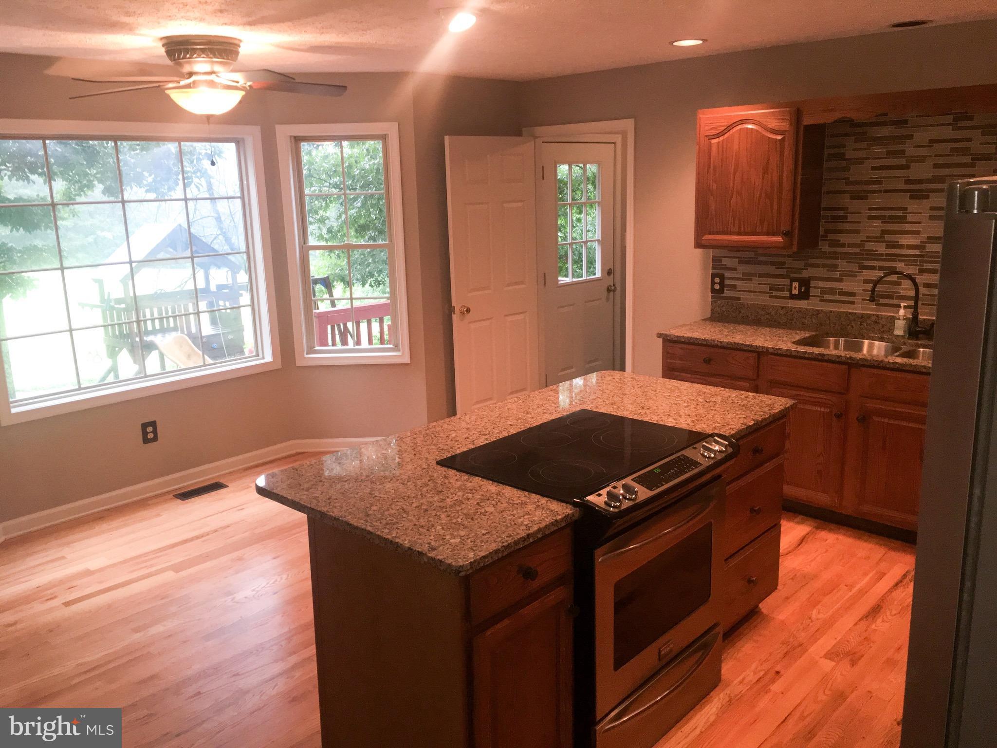 127 Holiday Road Cross Junction, VA 22625 - Photo 14 of 29 a kitchen with granite countertop a stove and a sink
