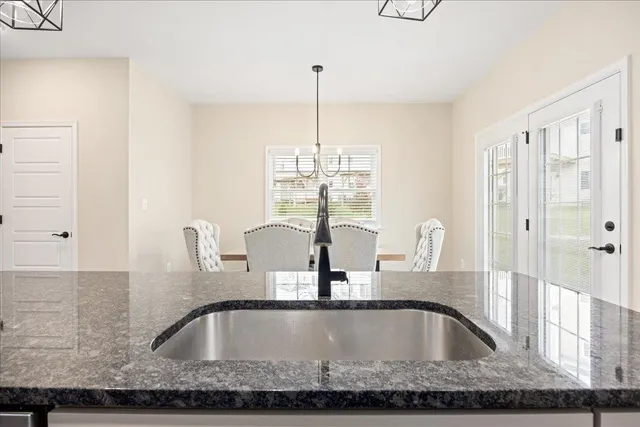 a kitchen counter with kitchen island a faucet a chandelier