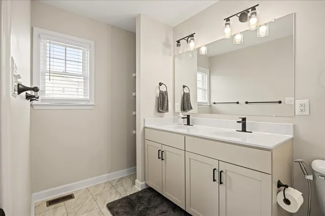 a bathroom with a granite countertop sink toilet and shower