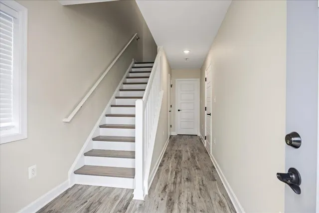 a view of a hallway with wooden floor and entryway