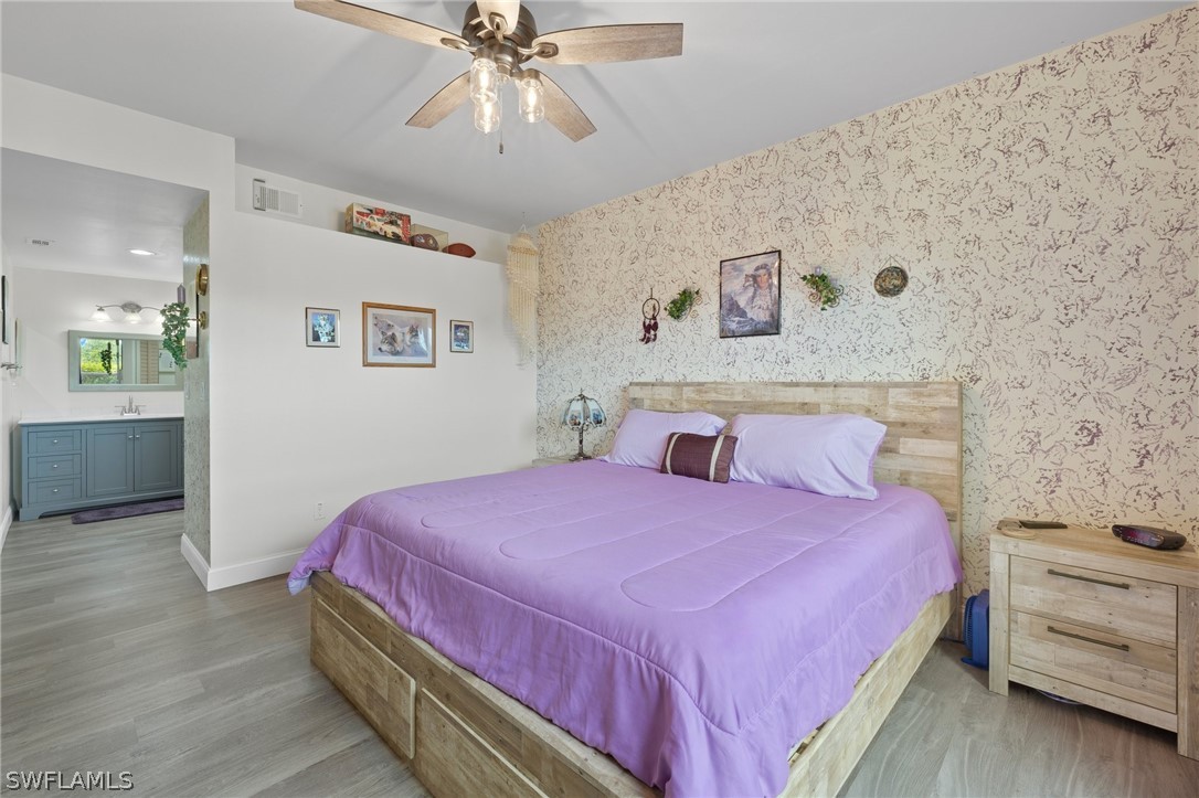 637 Windsor Square, Unit 102 Naples, FL 34104 - Photo 14 of 36 a bedroom with a bed and a chandelier