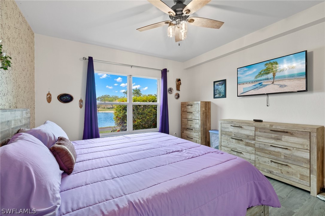 637 Windsor Square, Unit 102 Naples, FL 34104 - Photo 15 of 36 a bedroom with a bed and a flat screen tv