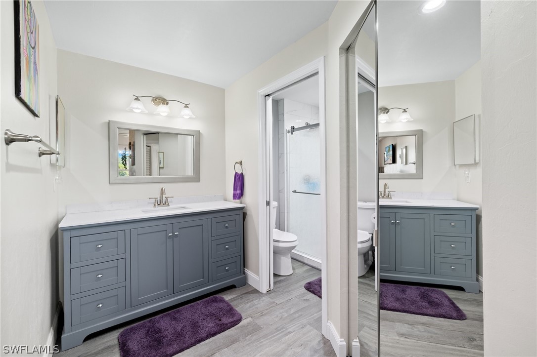637 Windsor Square, Unit 102 Naples, FL 34104 - Photo 16 of 36 a spacious bathroom with a toilet sink shower and mirror