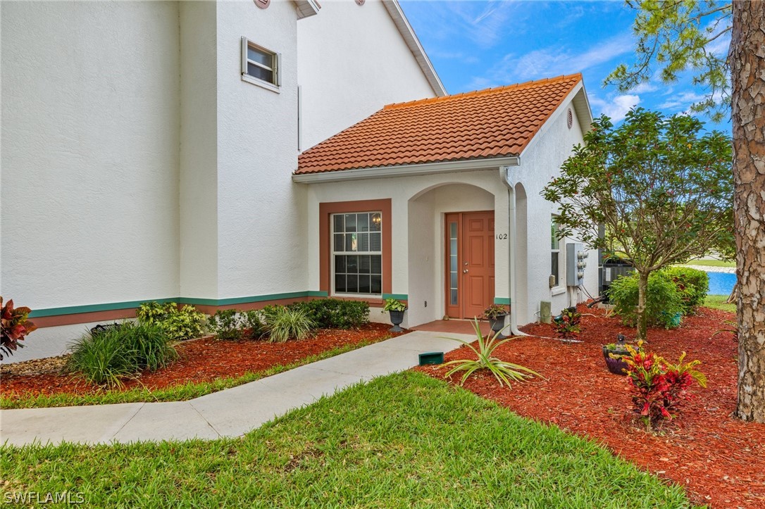 637 Windsor Square, Unit 102 Naples, FL 34104 - Photo 2 of 36 a front view of a house with a yard
