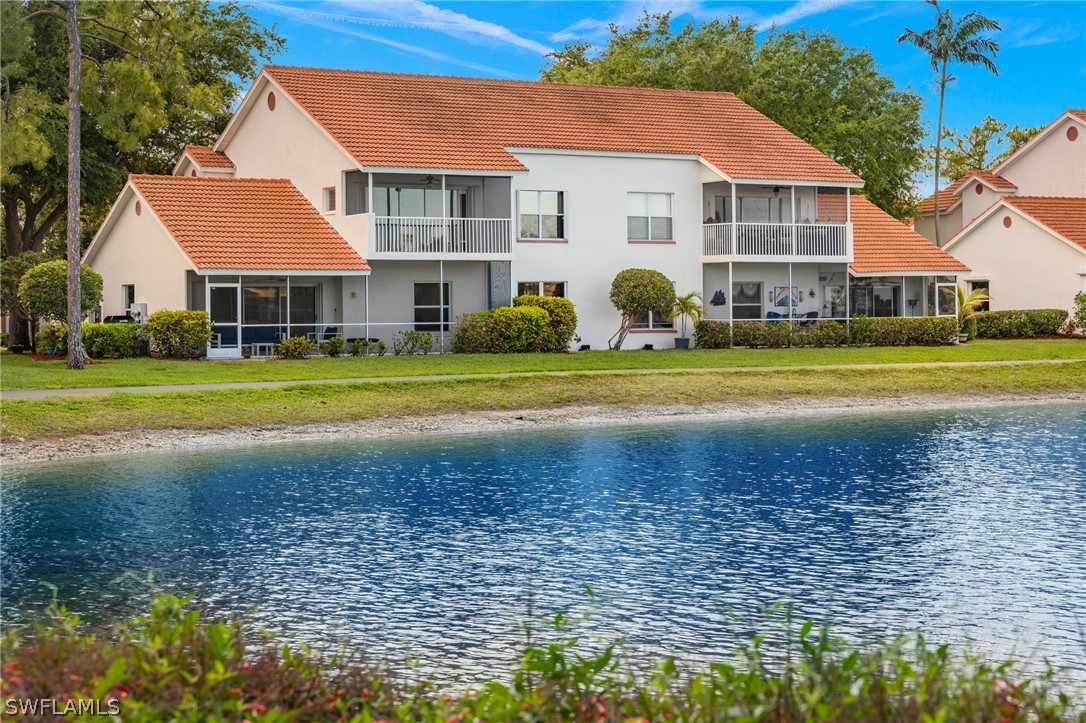 637 Windsor Square, Unit 102 Naples, FL 34104 - Photo 24 of 36 a front view of a house with a yard and trees