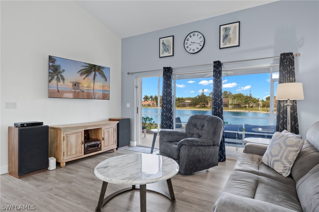 637 Windsor Square, Unit 102 Naples, FL 34104 - Photo 6 of 36 a living room with furniture a fireplace a lamp and a large window