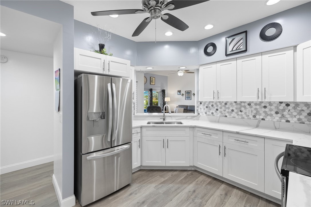 637 Windsor Square, Unit 102 Naples, FL 34104 - Photo 10 of 36 a kitchen with stainless steel appliances a refrigerator a sink and white cabinets