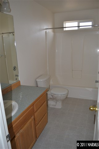 1190 Lattin Road Fallon, NV 89406 - Photo 8 of 9 a bathroom with a granite countertop sink a toilet and a shower