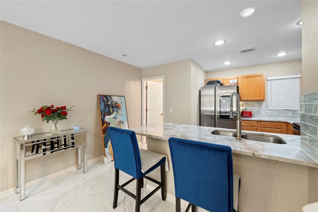 8825 White Sage Loop Lakewood Ranch, FL 34202 - Photo 14 of 33 a kitchen with granite countertop kitchen island stainless steel appliances a sink and a refrigerator