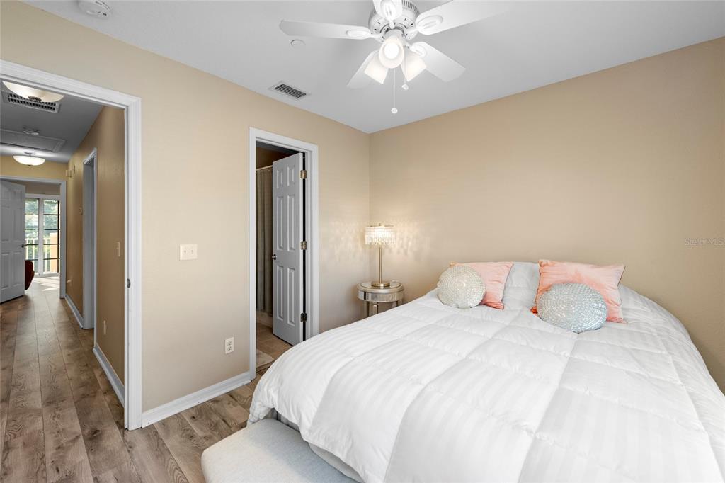 8825 White Sage Loop Lakewood Ranch, FL 34202 - Photo 27 of 33 a bedroom with a large bed and wooden floor