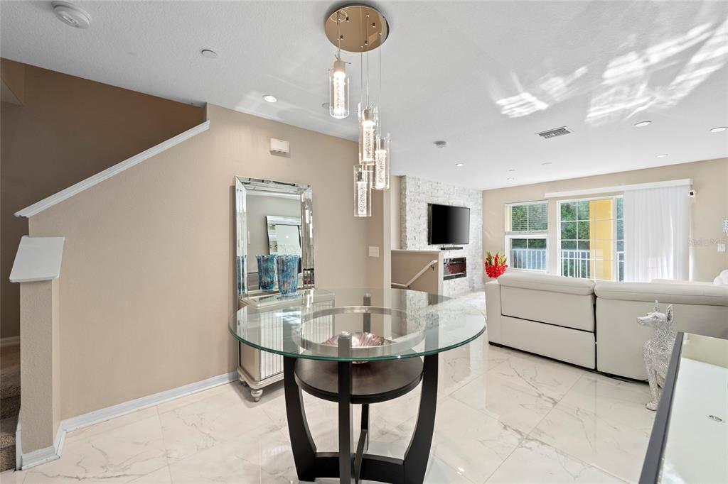 8825 White Sage Loop Lakewood Ranch, FL 34202 - Photo 10 of 33 a living room with furniture a chandelier and a flat screen tv