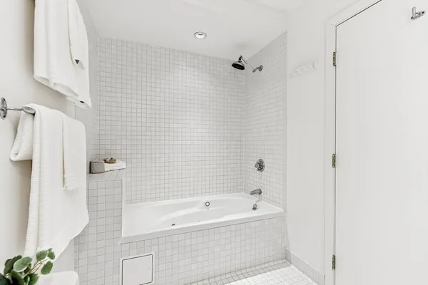 a bathroom with a bathtub a shower a toilet and a shower