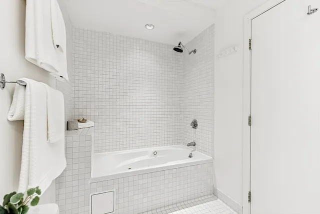 a bathroom with a bathtub a shower a toilet and a shower