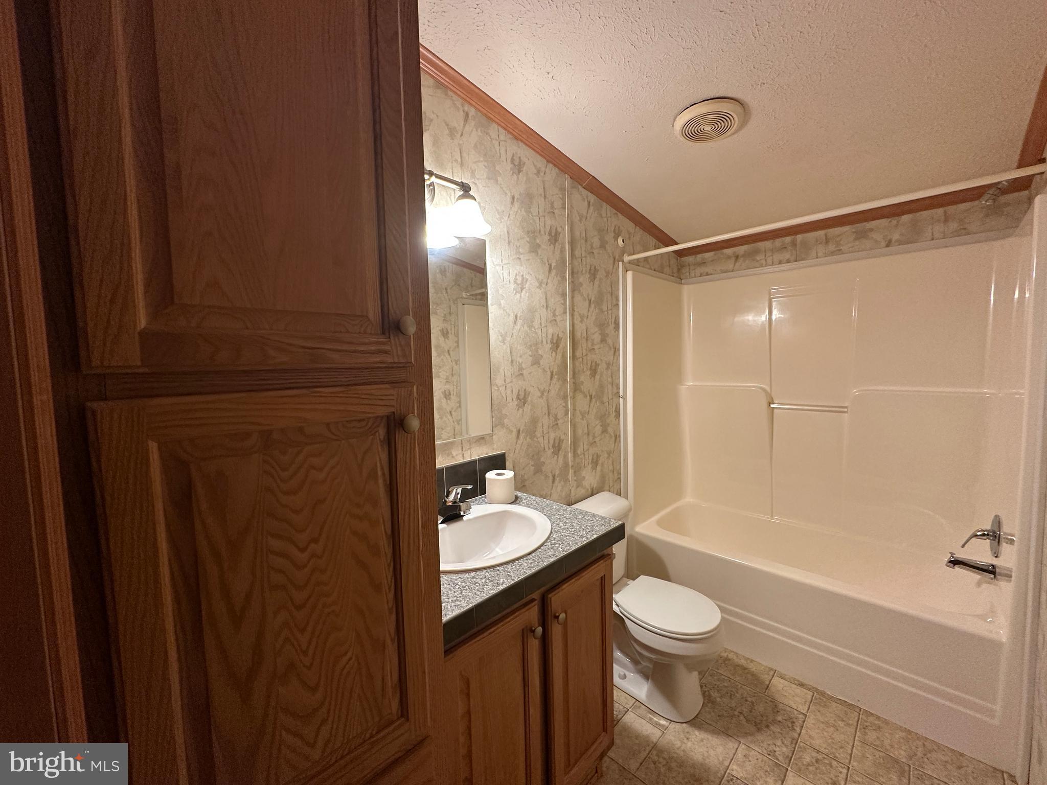 4391 Cito Road McConnellsburg, PA 17233 - Photo 62 of 67 a bathroom with a granite countertop sink toilet a mirror and shower