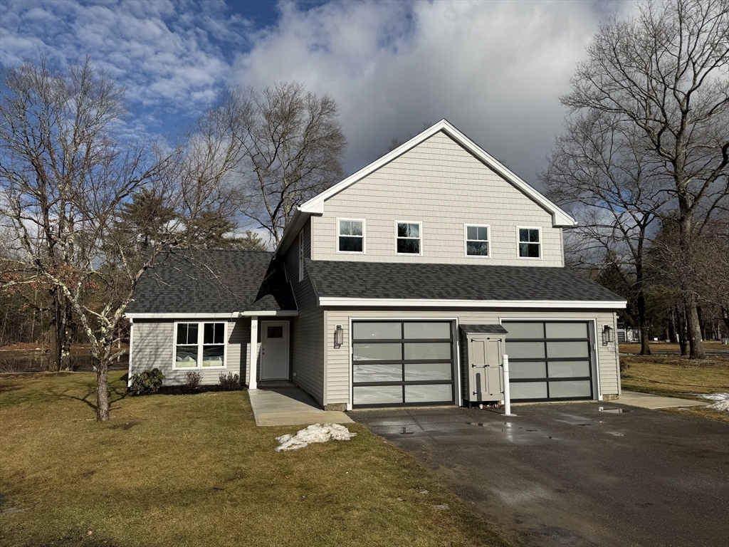 32 Barracks Road, Unit 32 Hudson, MA 01749 - Photo 15 of 16 a front view of a house with a garage and a yard