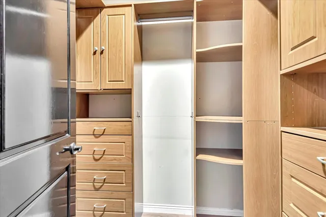 a view of walk in closet with empty racks