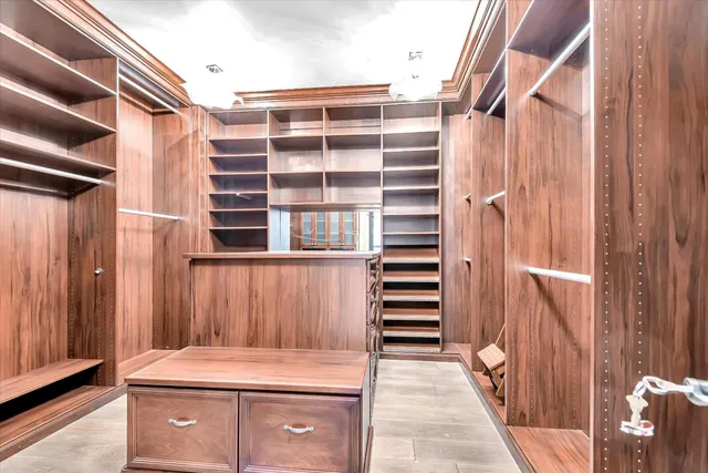 a view of walk in closet with clothes and shoes