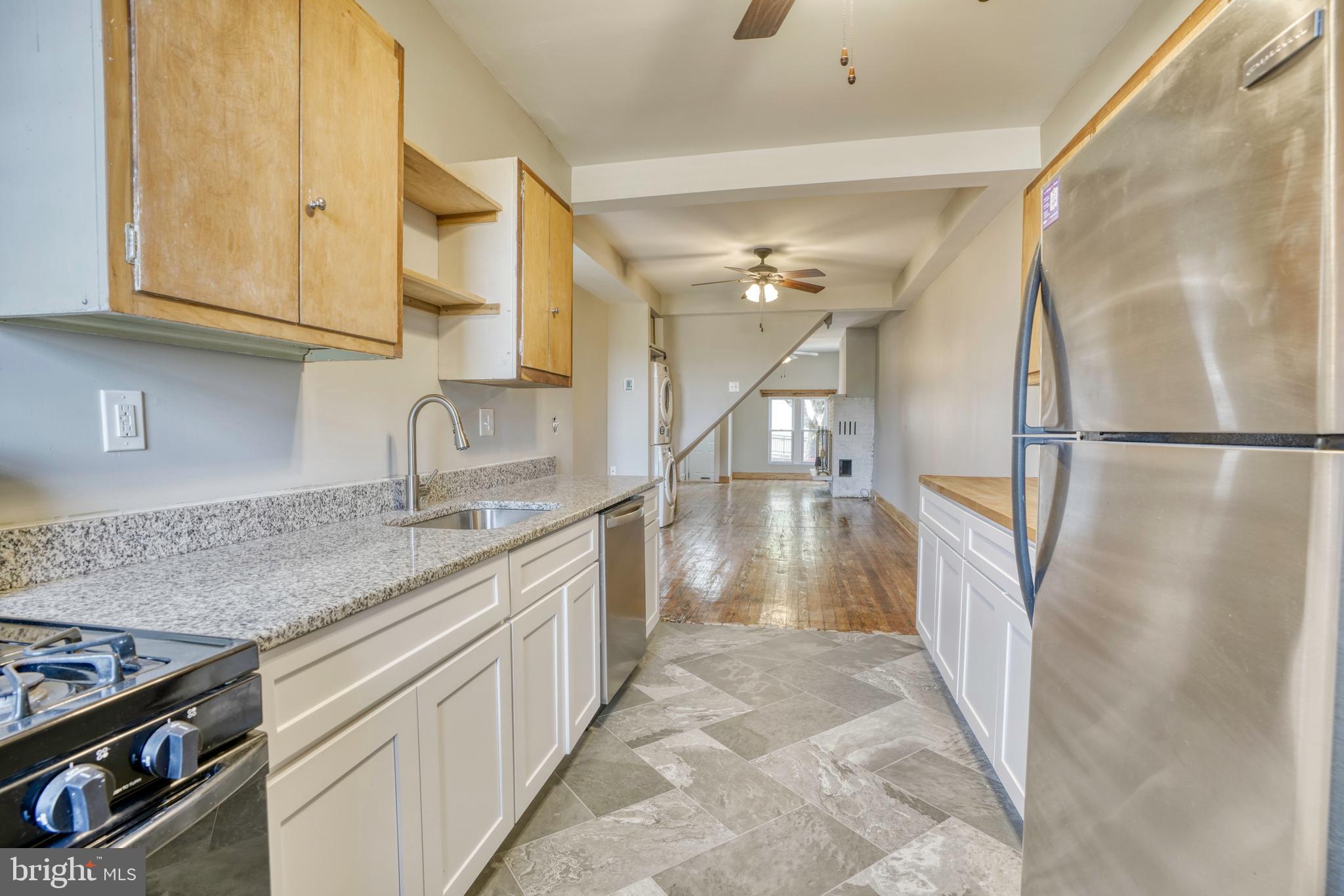 343 East 21st Street Baltimore, MD 21218 - Photo 6 of 22 a kitchen with granite countertop a sink a stove and refrigerator