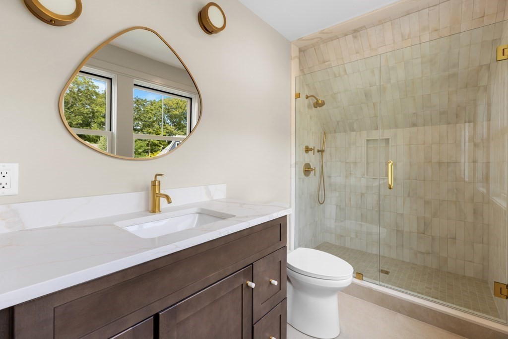 107 Valley Road Needham, MA 02492 - Photo 21 of 36 a bathroom with a sink a toilet and a mirror