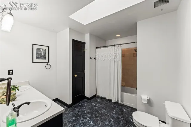 a bathroom with a granite countertop sink toilet and shower