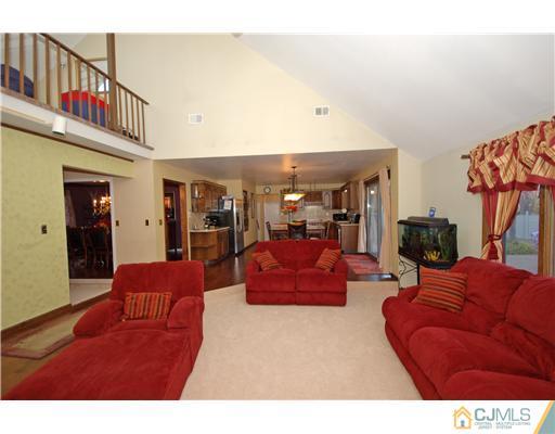 196 Friendship Road Cranbury, NJ 08512 - Photo 16 of 25 a living room with furniture a red rug and a floor to ceiling window