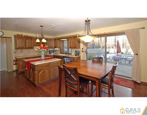 196 Friendship Road Cranbury, NJ 08512 - Photo 9 of 25 a kitchen with a stove a kitchen island a sink cabinets and wooden floor