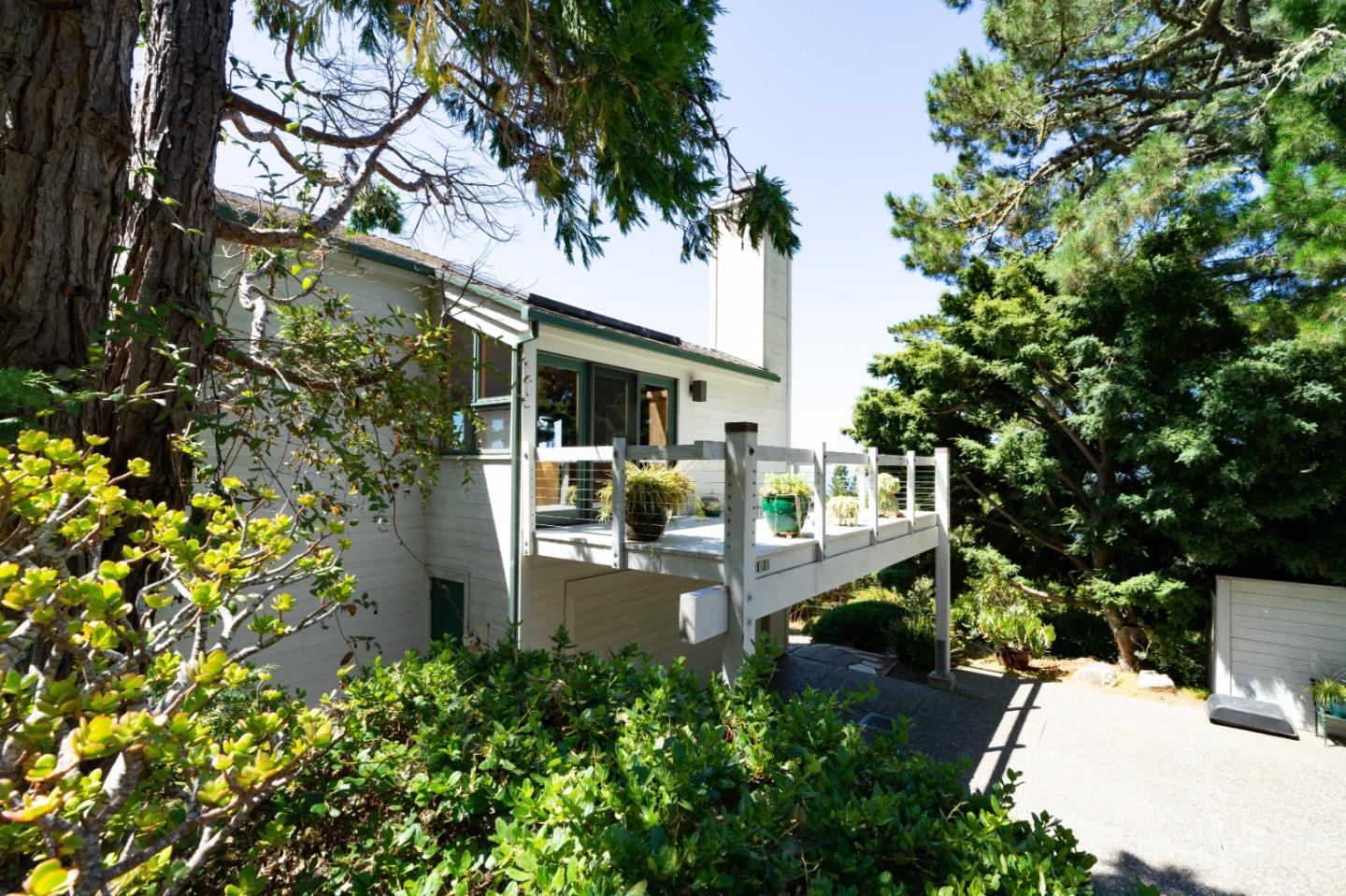 211 Crest Road Carmel, CA 93923 - Photo 16 of 21 a view of a patio with table and chairs potted plants and large tree