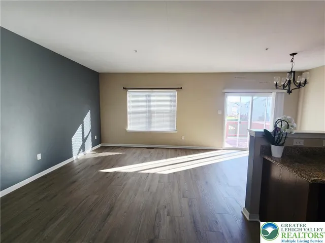 a view of a livingroom with wooden floor and a ceiling fan