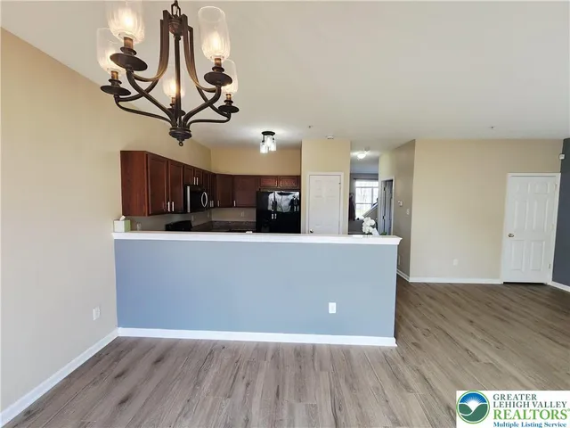 a view of a room with wooden floor and chandelier