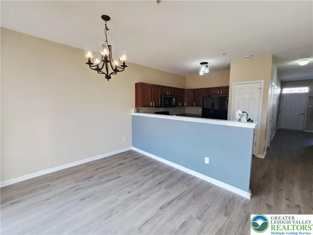 a view of a kitchen with wooden floor and stainless steel appliances