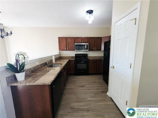 a kitchen with stainless steel appliances granite countertop a sink stove and refrigerator