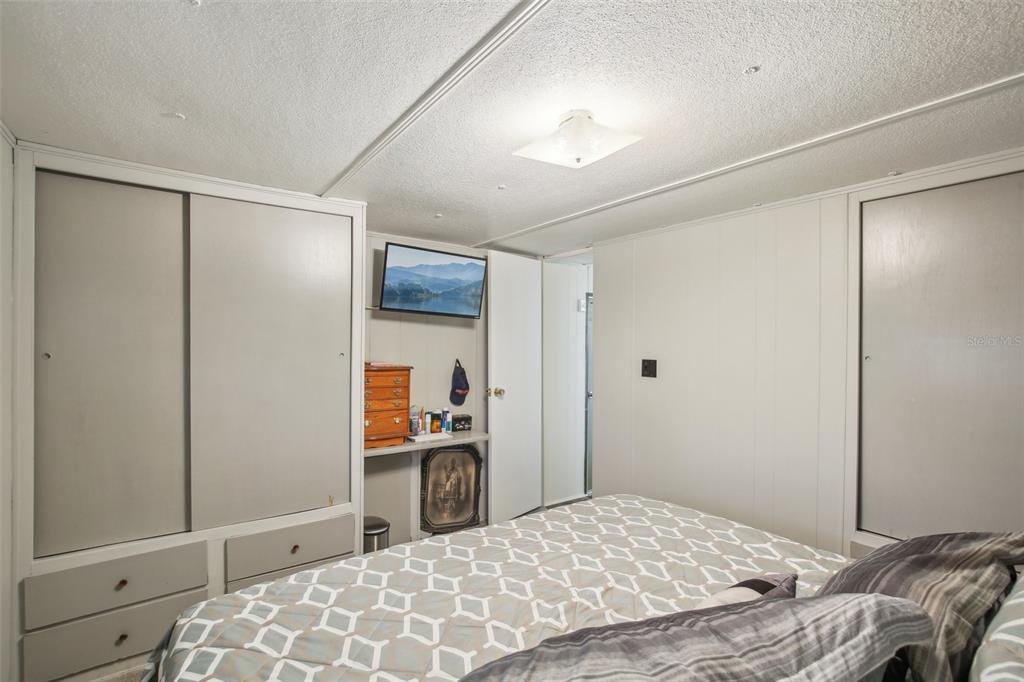 1600 Old Coachman Rd., Unit 311 Clearwater, FL 33765 - Photo 17 of 27 a bedroom with a bed and a dresser in it