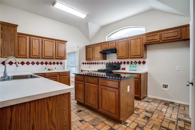 a kitchen with stainless steel appliances a sink stove and cabinets