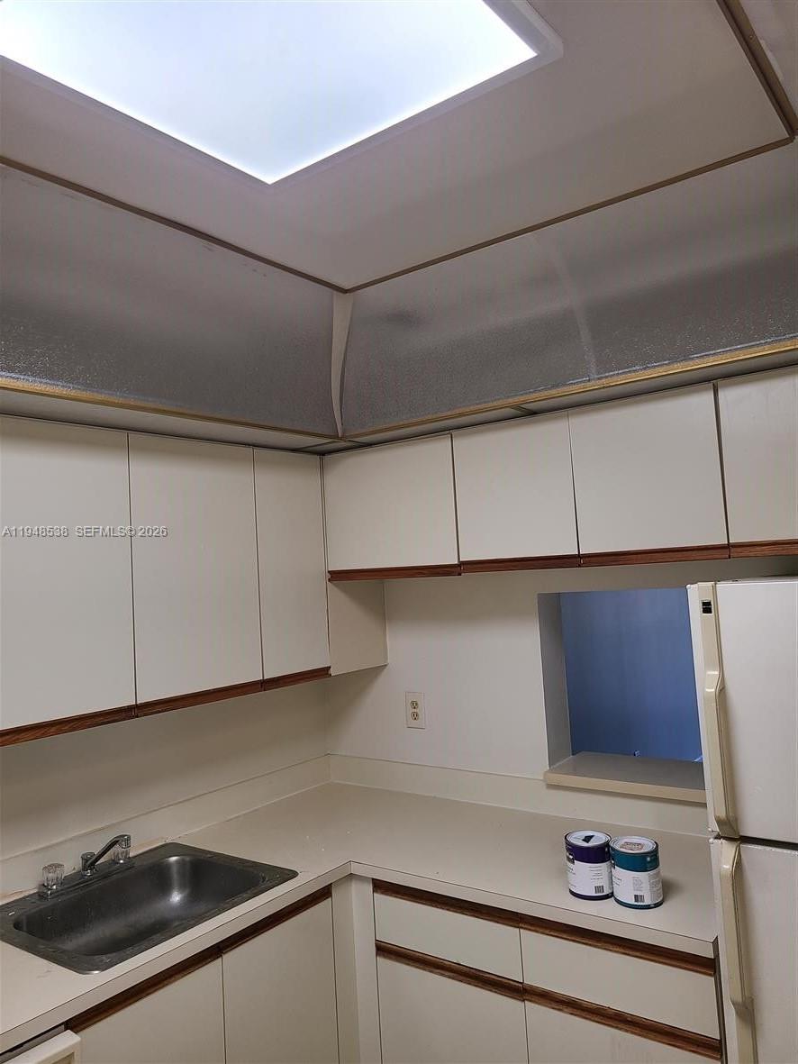 7925 South Colony Circle, Unit 207 Tamarac, FL 33321 - Photo 6 of 10 a kitchen with a sink and cabinets