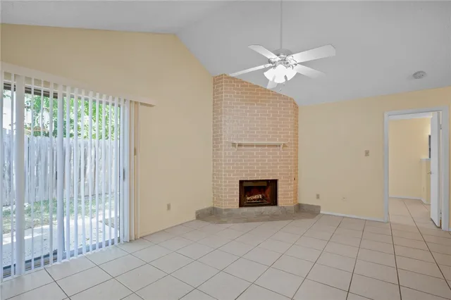 a view of an empty room with a fireplace and a window