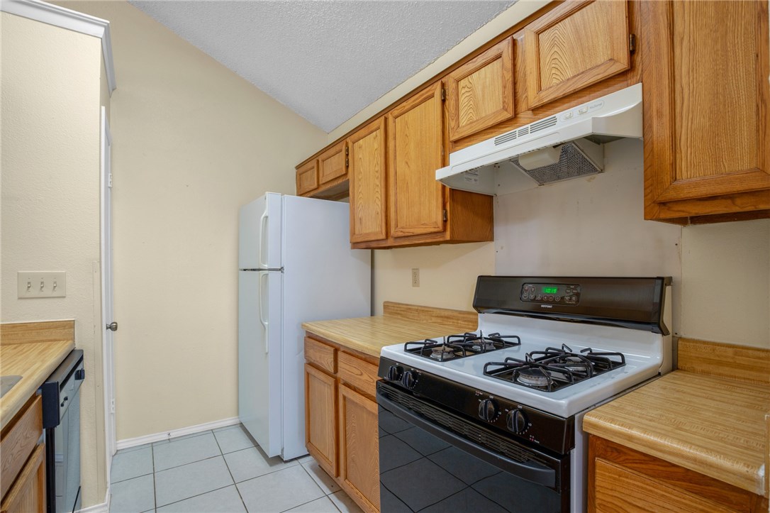 12213 Tyson Cove, Unit B Austin, TX 78758 - Photo 7 of 15 a kitchen with stainless steel appliances granite countertop a stove and a refrigerator