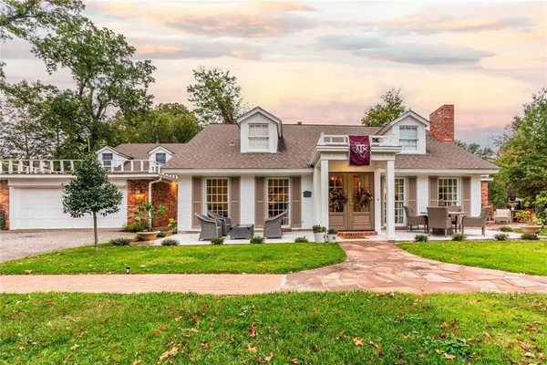 a front view of a house with a yard and trees