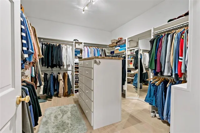 a view of walk in closet with clothes and shoes