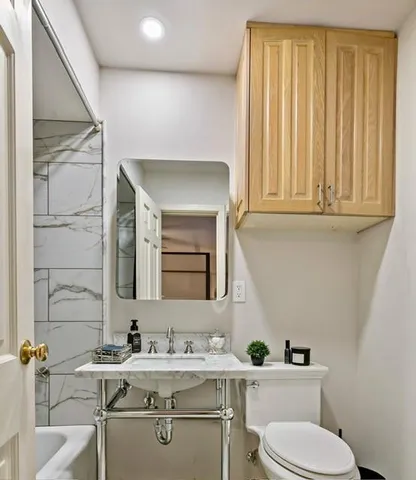 a bathroom with a toilet sink and mirror