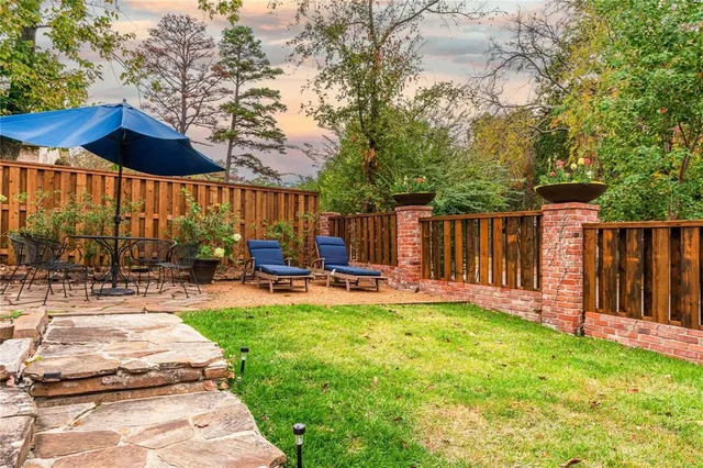 a view of a chair and table under an umbrella in backyard