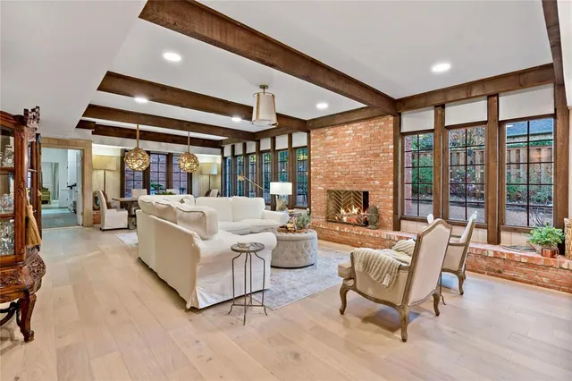 a living room with fireplace furniture and a large window