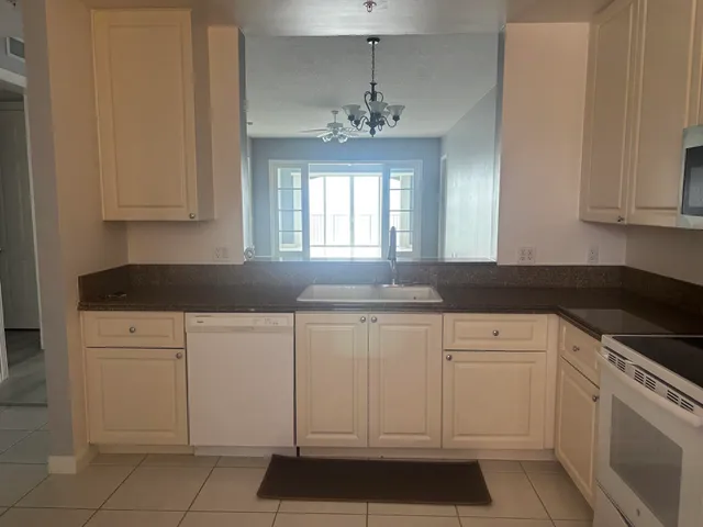 a kitchen with white cabinets granite counter tops and a stove