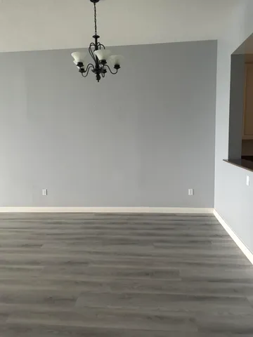 a view of a room with wooden floor and chandelier