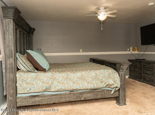 780 Cedar Court Rifle, CO 81650 - Photo 16 of 31 a bedroom with a bed and a chandelier