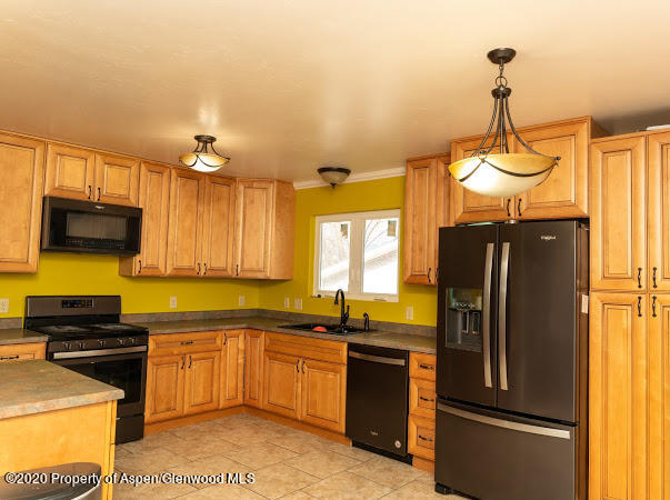 780 Cedar Court Rifle, CO 81650 - Photo 2 of 31 a kitchen with a refrigerator a microwave a sink and a stove