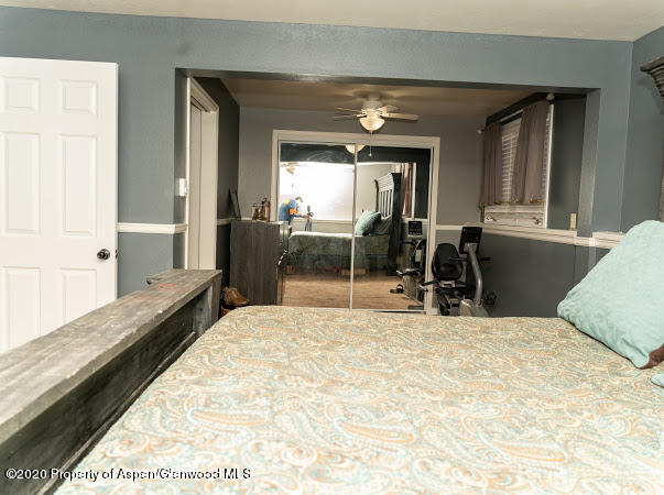 780 Cedar Court Rifle, CO 81650 - Photo 21 of 31 a bedroom with a bed and large windows