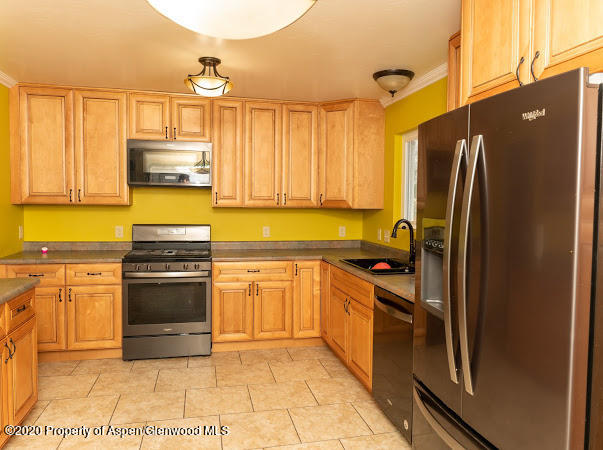 780 Cedar Court Rifle, CO 81650 - Photo 7 of 31 a kitchen with stainless steel appliances granite countertop a refrigerator a stove and a sink